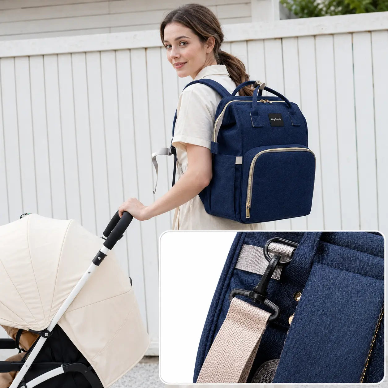 Mother carrying the Heyoravix navy convertible diaper backpack beside a stroller