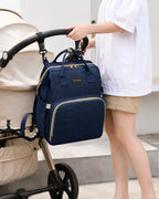 Heyoravix navy convertible diaper backpack hanging from a stroller handle