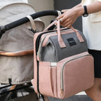Heyoravix convertible diaper backpack in pink and grey attached to a stroller